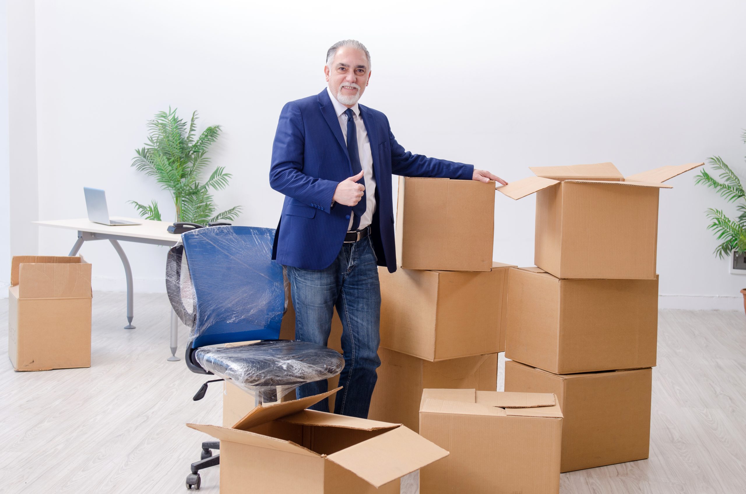 Mann im Büro mit Umzugskartons
